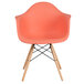 A Flash Furniture Alonza peach plastic chair with wooden legs.