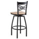 A Lancaster Table & Seating black and wood swivel bar stool with a backrest and wooden seat.