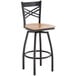 A Lancaster Table & Seating black and wood swivel bar stool with a back and wooden seat.