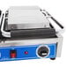 A Globe commercial panini grill with blue and silver metal plates.