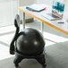 A gray Champion FitPro ball chair next to a laptop on a table.