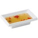 A white rectangular GET Water Lily sauce dish with liquid in it.