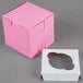 A pink Baker's Mark cupcake box with a cut out window.