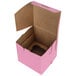 A pink Baker's Mark cupcake box with a hole in the top.