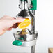 A person using a Garde squeezer to juice a lemon.