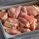 A tray of frozen boneless skinless chicken thighs.