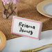 A Choice ceramic table tent sign with a rose decal border on a table with a name card that says "Brian Jones"