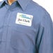 A man wearing a blue shirt with an Avery white rectangle name tag.