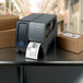 A label printer printing Avery White Industrial Direct Thermal Labels for boxes on a table.