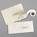 A roll of white Avery multipurpose labels with black text on a white envelope.