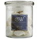 A glass jar of white shells with a square clear Avery label that says ww.
