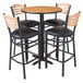A Lancaster Table & Seating bar height table with a reversible walnut and oak top and four black padded Bistro chairs.