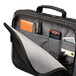 A black Case Logic clamshell laptop bag with a pocket inside holding a cell phone and other items.