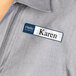 A woman wearing an Avery removable name badge that says "Hello Karen" on her shirt.