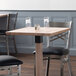 A Lancaster Table & Seating solid wood live edge table top with two chairs.
