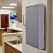 A wall-mounted grey Rubbermaid storage cabinet for biohazard spill mop pads.