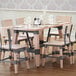 A Lancaster Table & Seating live edge wood table top with wine glasses and chairs on it.