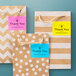 A group of brown and white thank you gift bags with different colored Avery labels.