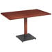 A Lancaster Table & Seating rectangular wooden table with a black base.