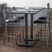 A Lancaster Table & Seating bar height table with chairs around it.