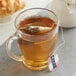 A glass mug of Numi Organic Golden Chai Tea with a tea bag in it.