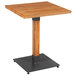 A Lancaster Table & Seating square wooden table with a metal base.