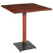 A Lancaster Table & Seating square wooden bar height table with a metal base.