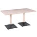 A Lancaster Table & Seating live edge table with two black legs and a white pole.
