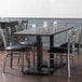 A Lancaster Table & Seating live edge dining table with chairs and glasses around it.
