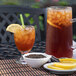 A glass of Numi 1 Gallon Organic High Mountain Black Iced Tea with ice and lemon slices on a table.