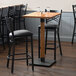 A Lancaster Table & Seating live edge bar height table with glasses on it.