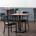 A Lancaster Table & Seating mahogany wood table and chair set in a restaurant.