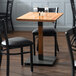 A Lancaster Table & Seating solid wood dining table with a live edge and antique natural finish.
