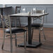 An antique slate gray Lancaster Table & Seating wooden dining height table base with two chairs.