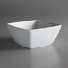 A Oneida Fusion bright white porcelain square bowl on a gray surface.