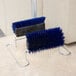 A pair of blue Carlisle shoe brushes on a stand.