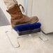 A brown boot on a Carlisle blue shoe brush stand.