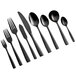 A close-up of several Bon Chef black stainless steel soup/dessert spoons.