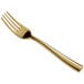 A close-up of a Bon Chef gold stainless steel salad fork with a gold handle.