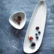 A Oneida porcelain tray with blueberries, figs, and chocolate on it.