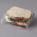 A sandwich wrapped in LK Packaging clear plastic.