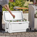 A man putting beer into a white CaterGator outdoor cooler.