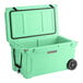 A seafoam green CaterGator outdoor cooler with wheels.