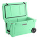 A seafoam green CaterGator outdoor cooler with wheels.