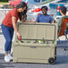 A woman putting a drink into a CaterGator outdoor cooler.