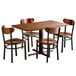 A Lancaster Table & Seating solid wood live edge dining table with four chairs.