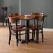 A Lancaster Table & Seating solid wood dining table with four chairs.