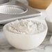 A white bowl of Bob's Red Mill gluten-free baking flour next to muffin tins.