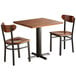 A Lancaster Table & Seating solid wood live edge dining table with two wooden chairs.