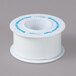 A white roll of Medi-First first aid tape with blue writing on it.